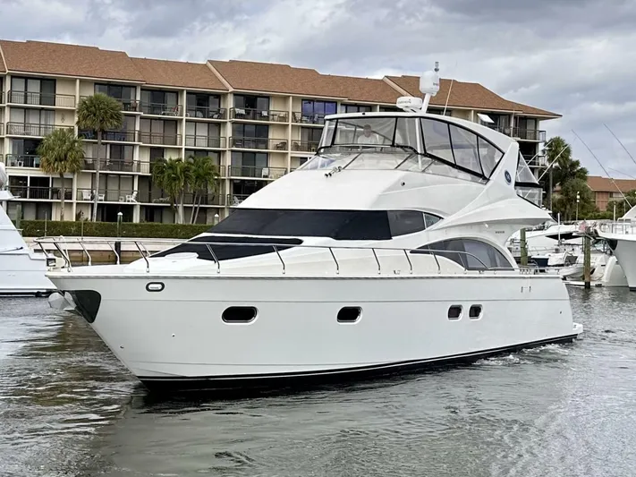  Yacht Photos Pics 2006 Marquis Flybridge Motor Yacht docked near waterfront apartments.