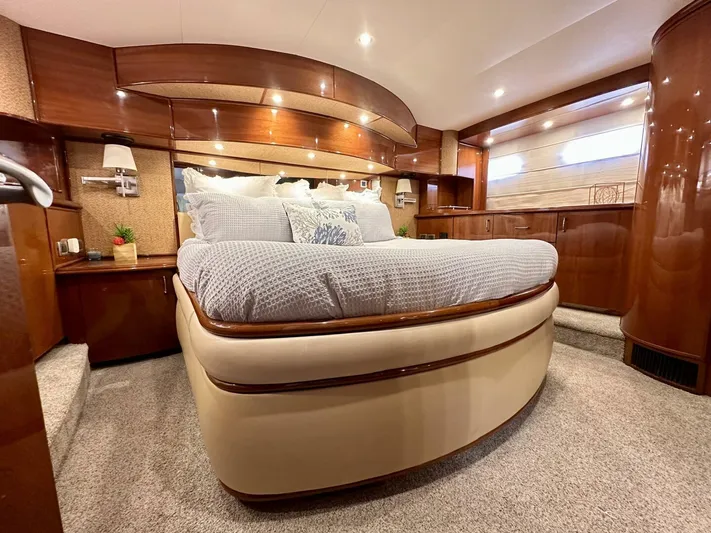  Yacht Photos Pics Luxurious bedroom interior of a 2006 Marquis Flybridge Motor Yacht with elegant wood finishes.