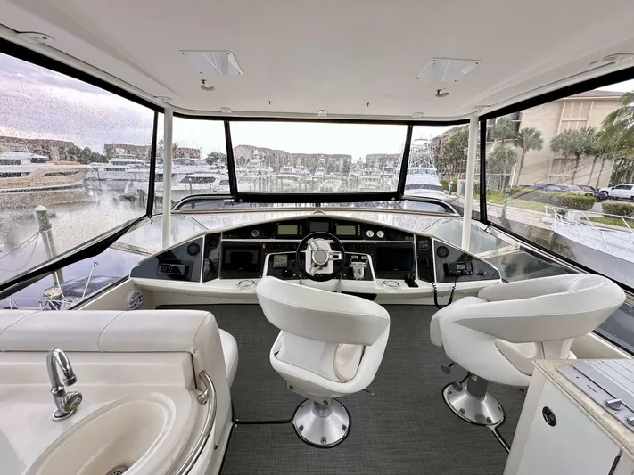  Yacht Photos Pics 2006 Marquis Flybridge Motor Yacht interior with helm, luxurious seating, and panoramic marina view.
