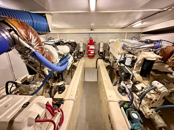  Yacht Photos Pics Engine room of a 2006 Marquis Flybridge Motor Yacht with visible machinery and fire extinguisher.
