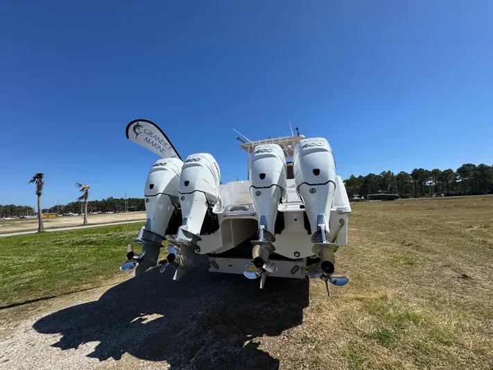  Yacht Photos Pics 2023 Invincible 37 Catamaran with four powerful outboard engines, displayed outdoors under clear blue sky.