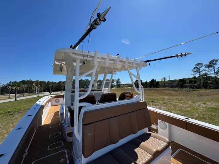  Yacht Photos Pics 2023 Invincible 37 Catamaran with fishing rods, brown seating, and clear blue sky.