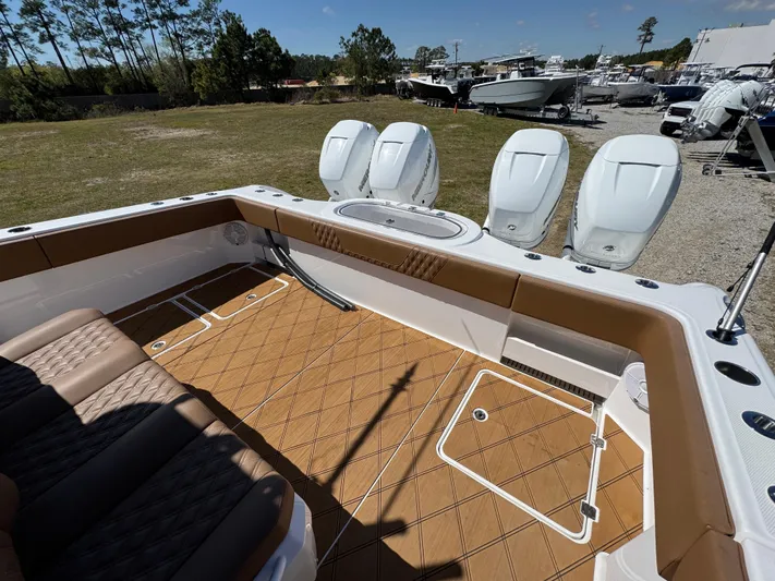  Yacht Photos Pics 2023 Invincible 37 Catamaran with tan deck, triple outboard engines, and spacious seating area.