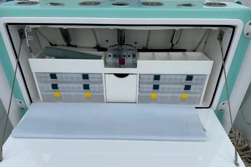  Yacht Photos Pics Stanley White Fishmaster 2026 boat storage compartment with organized tackle boxes and accessories.