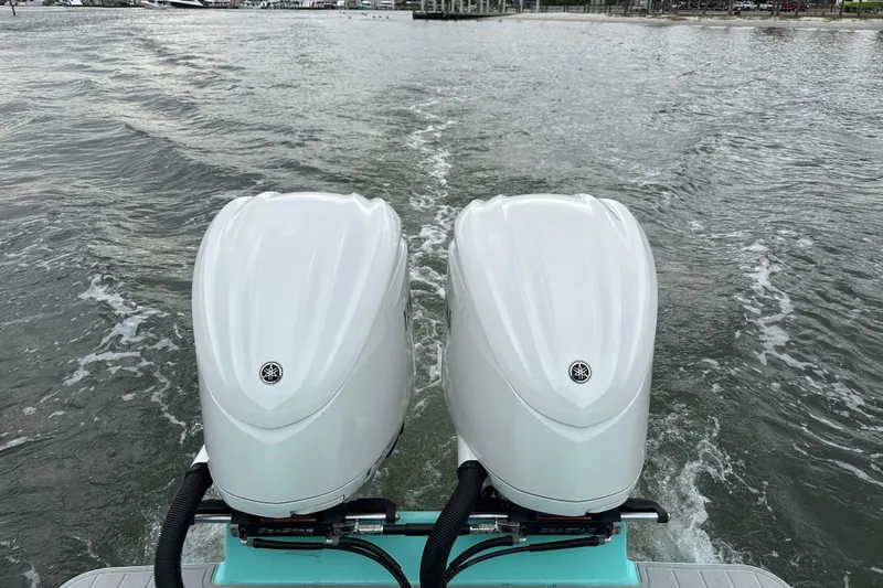  Yacht Photos Pics Twin outboard motors on a 2026 Stanley White Fishmaster boat navigating water.