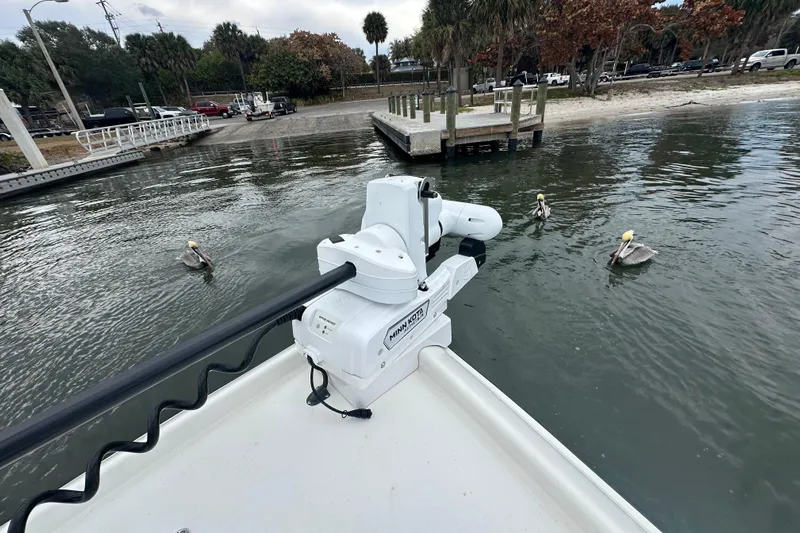  Yacht Photos Pics Stanley White Fishmaster 2026 boat with pelicans near a dock in calm waters.