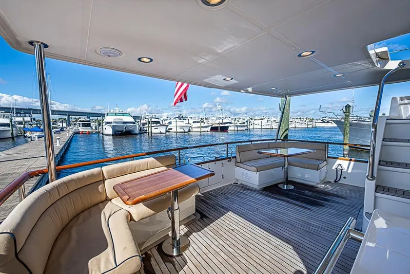 Ben's Barge Yacht Photos Pics Luxurious 2014 Marlow Explorer 66E yacht deck with seating, docked at marina.