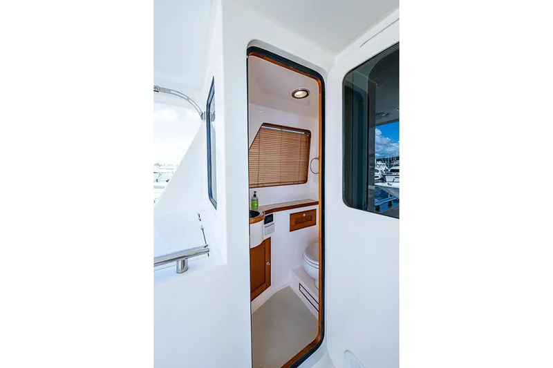 Ben's Barge Yacht Photos Pics 2014 Marlow Explorer 66E yacht bathroom interior with wooden accents and window blinds.