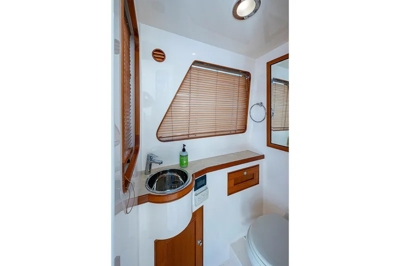 Ben's Barge Yacht Photos Pics Luxurious bathroom in 2014 Marlow Explorer 66E yacht with wooden accents and modern fixtures.
