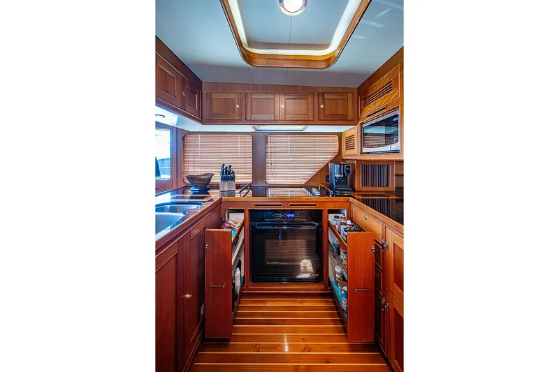 Ben's Barge Yacht Photos Pics Luxurious kitchen interior of 2014 Marlow Explorer 66E yacht with wooden cabinetry and modern appliances.