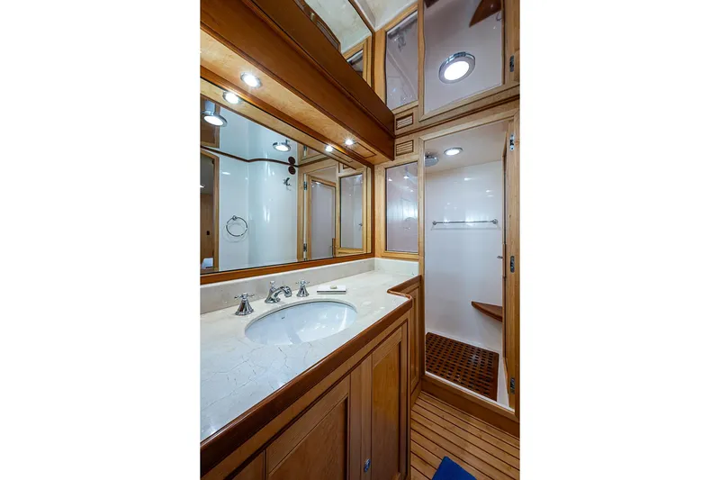 Ben's Barge Yacht Photos Pics Luxurious bathroom in 2014 Marlow Explorer 66E yacht with wooden cabinetry and modern fixtures.