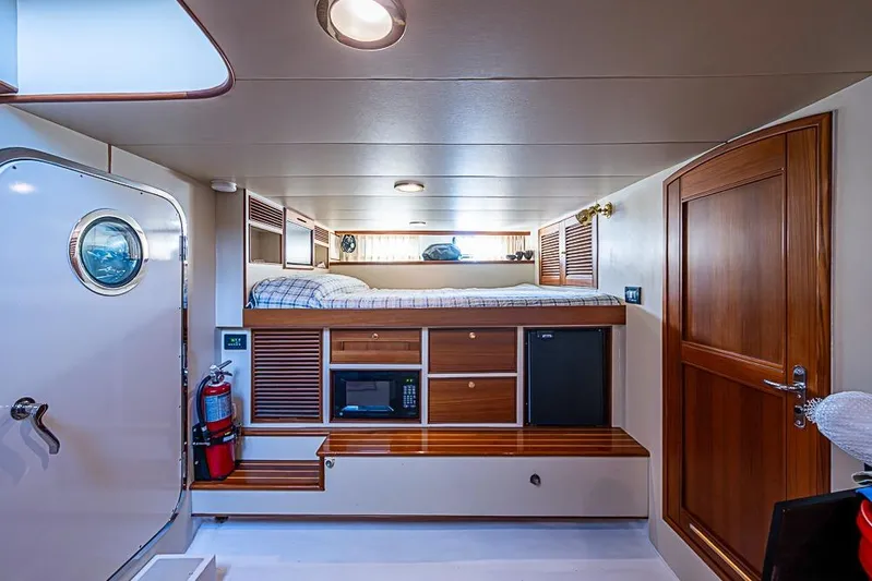 Ben's Barge Yacht Photos Pics Cozy cabin interior of 2014 Marlow Explorer 66E yacht with bed, storage, and porthole.