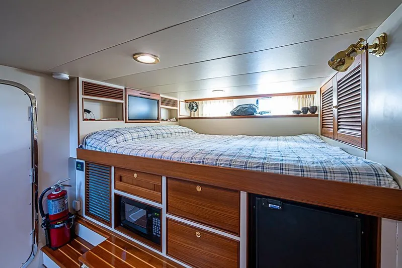 Ben's Barge Yacht Photos Pics Cozy cabin interior of 2014 Marlow Explorer 66E yacht with bed and storage.