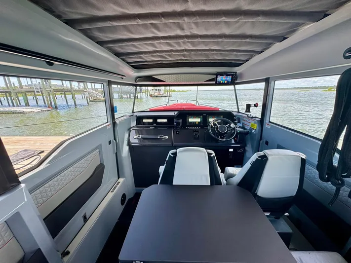  Yacht Photos Pics 2023 Axopar Shadow 900XC interior with modern helm and seating, overlooking water.