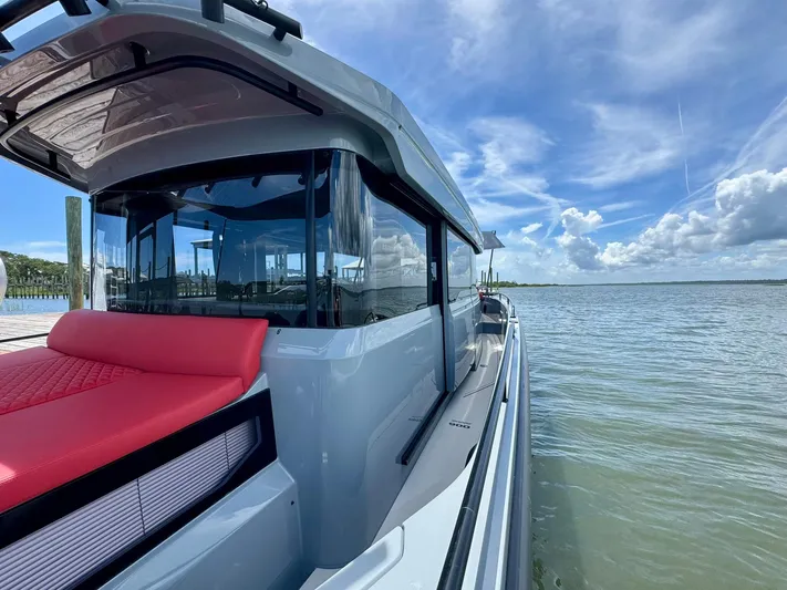  Yacht Photos Pics 2023 Axopar Shadow 900XC boat on calm water under a blue sky.