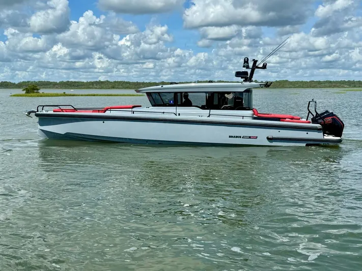  Yacht Photos Pics 2023 Axopar Shadow 900XC boat on calm water under a cloudy sky.