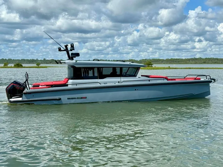  Yacht Photos Pics 2023 Axopar Shadow 900XC boat on calm water under cloudy sky.