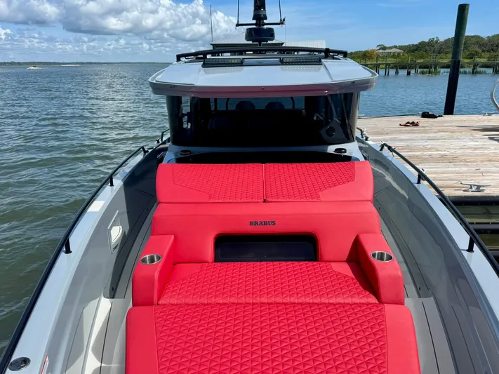  Yacht Photos Pics 2023 Axopar Shadow 900XC with vibrant red seating, docked by a serene waterfront.