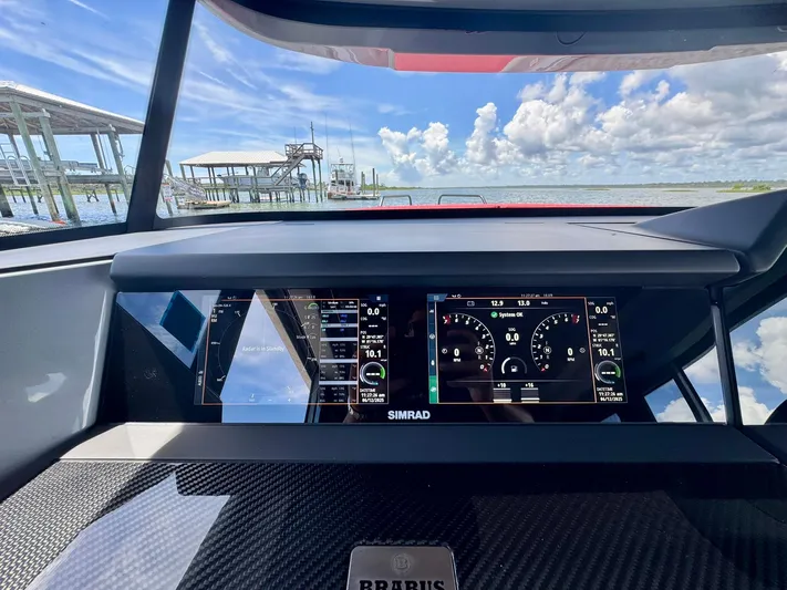  Yacht Photos Pics Dashboard view of 2023 Axopar Shadow 900XC boat with digital displays and scenic water background.