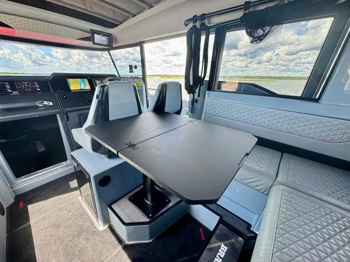  Yacht Photos Pics Interior of 2023 Axopar Shadow 900XC boat with modern seating and table setup.