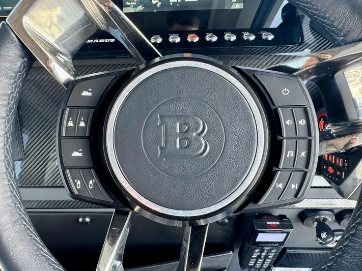  Yacht Photos Pics Steering wheel of 2023 Axopar Shadow 900XC with control buttons and carbon fiber accents.