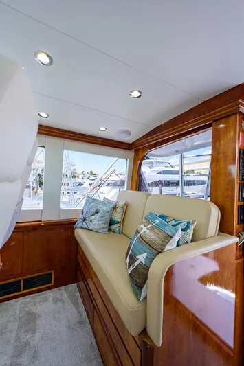  Yacht Photos Pics Interior of 2001 Hatteras 60 Enclosed Bridge yacht with cushioned seating and decorative pillows.