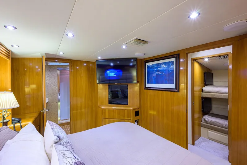  Yacht Photos Pics Luxurious bedroom interior of 2001 Hatteras 60 enclosed bridge yacht with TV and bunk beds.