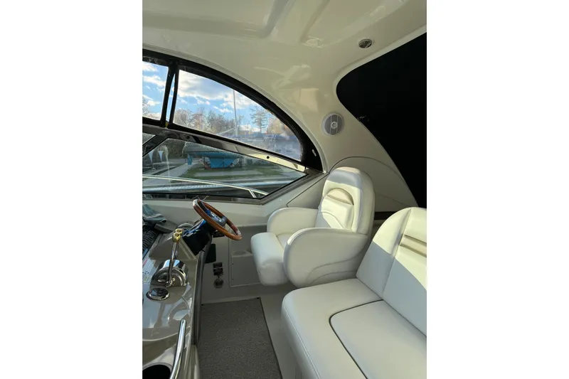  Yacht Photos Pics 2006 Sea Ray 38 Sundancer interior with white seating and wooden steering wheel.