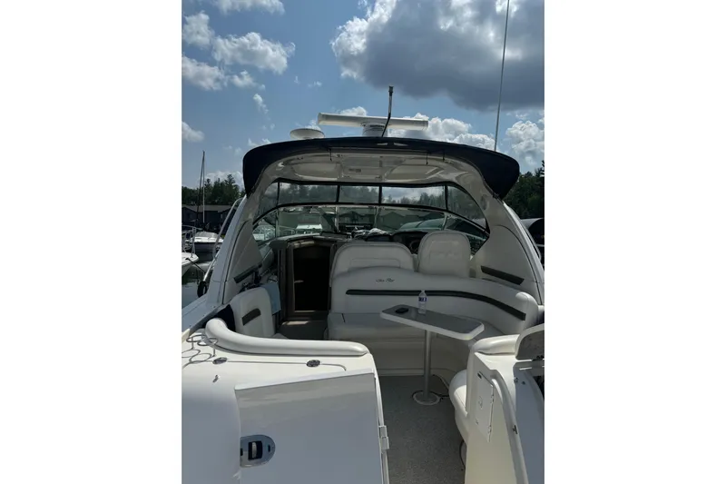  Yacht Photos Pics 2006 Sea Ray 38 Sundancer yacht interior with seating and table under a cloudy sky.