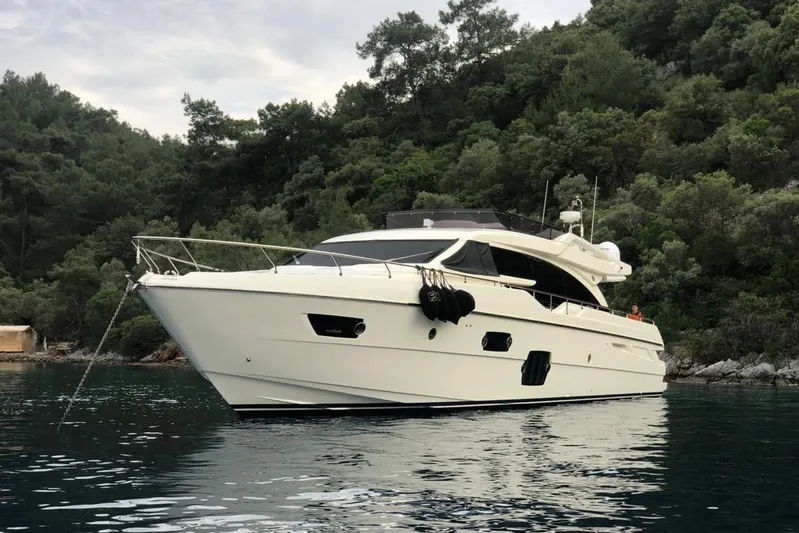  Yacht Photos Pics 2013 Ferretti Yachts 690 anchored in serene waters, surrounded by lush greenery.