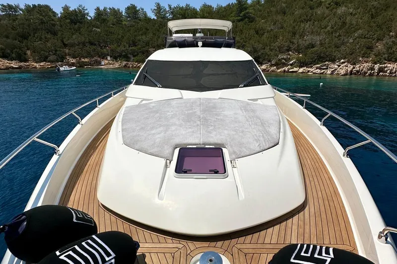  Yacht Photos Pics Ferretti Yachts 690, 2013 model, anchored in clear blue waters near a forested shoreline.