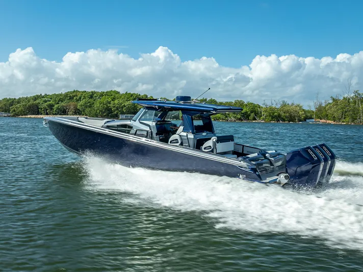  Yacht Photos Pics 2024 Nor-Tech 450 Sport Center Console cruising on water, showcasing sleek design and powerful engines.
