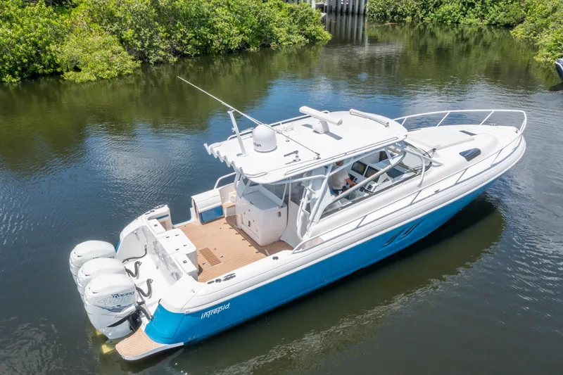  Yacht Photos Pics 2018 Intrepid 430 Sport Yacht cruising on a calm river, surrounded by lush greenery.