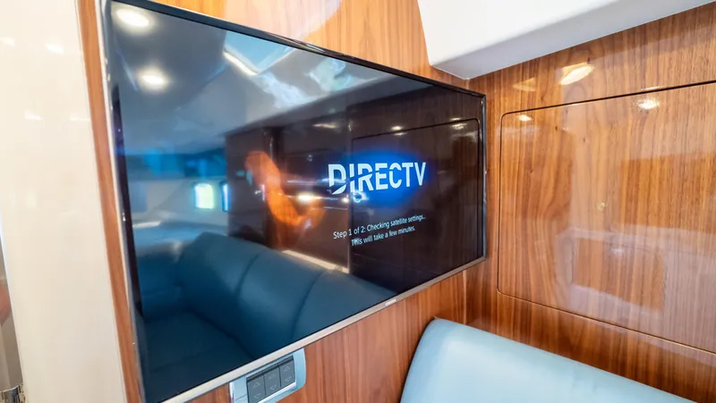  Yacht Photos Pics 2018 Intrepid 430 Sport Yacht interior with TV displaying DirecTV, featuring sleek wood paneling.
