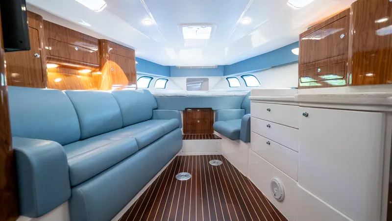  Yacht Photos Pics Luxurious interior of 2018 Intrepid 430 Sport Yacht with blue seating and wood accents.