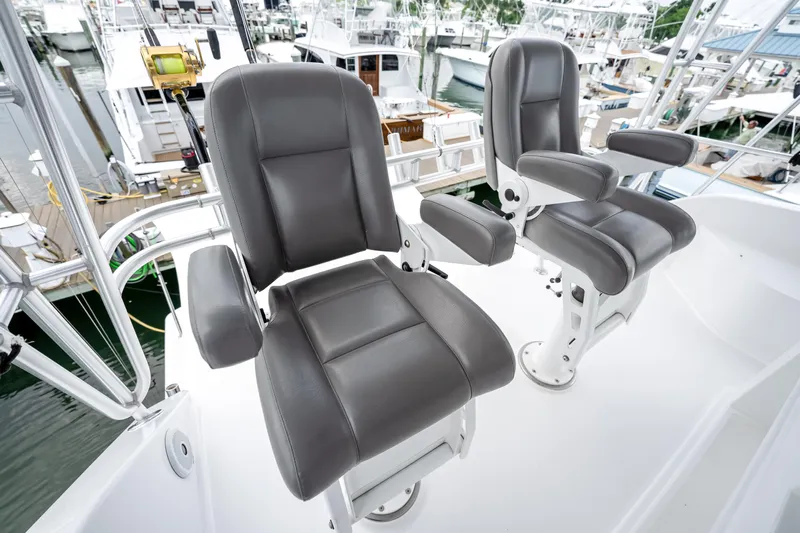Second Chance Yacht Photos Pics Two gray captain's chairs on a 1995 Viking 50 yacht, docked at a marina.