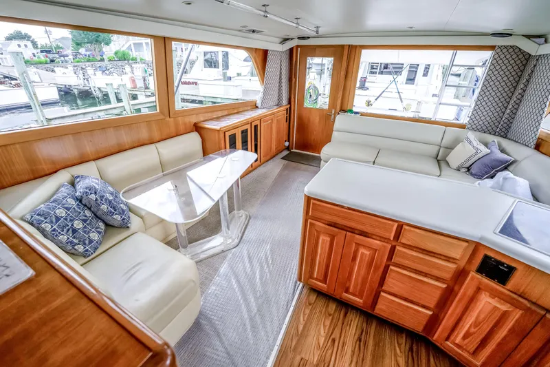 Second Chance Yacht Photos Pics Luxurious interior of a 1995 Viking 50 yacht with plush seating and elegant wood finishes.