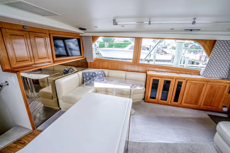 Second Chance Yacht Photos Pics Luxurious interior of a 1995 Viking 50 yacht with plush seating and wooden cabinetry.