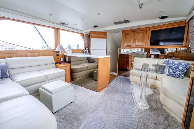 Second Chance Yacht Photos Pics Luxurious interior of a 1995 Viking 50 yacht with white leather seating and wooden cabinetry.