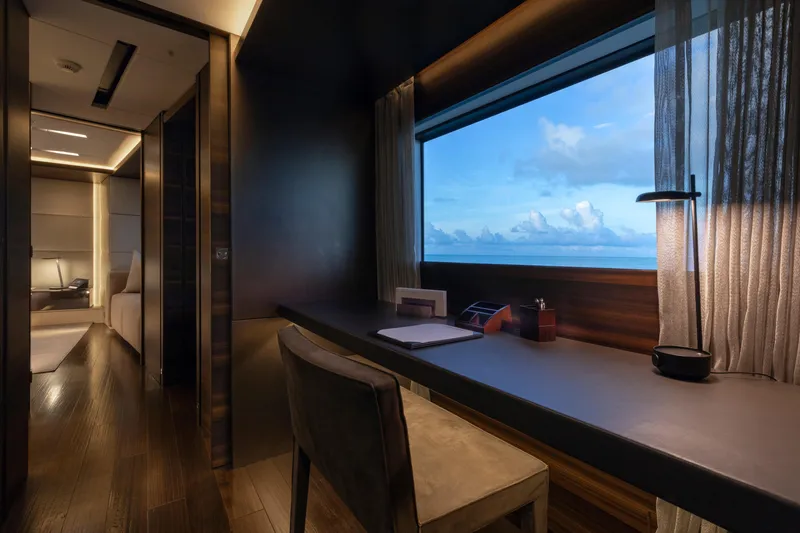 Safe Haven Yacht Photos Pics Luxurious yacht interior with ocean view, featuring a sleek desk and modern decor.