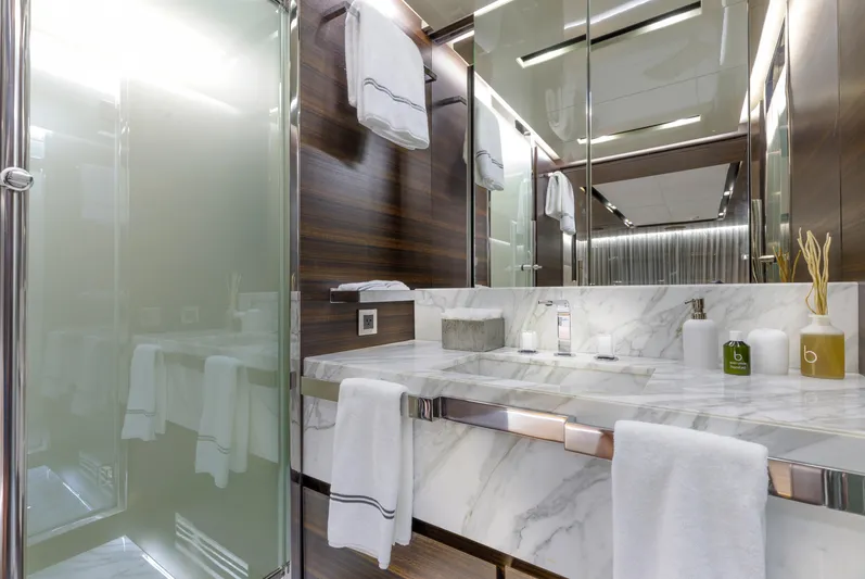 Safe Haven Yacht Photos Pics Luxurious yacht bathroom with marble countertop, glass shower, and elegant wood paneling, 2015 Admiral Custom.