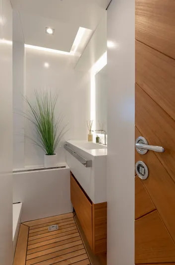 Safe Haven Yacht Photos Pics Modern yacht bathroom with wooden accents, sleek sink, and decorative plant. Admiral Custom 2015.