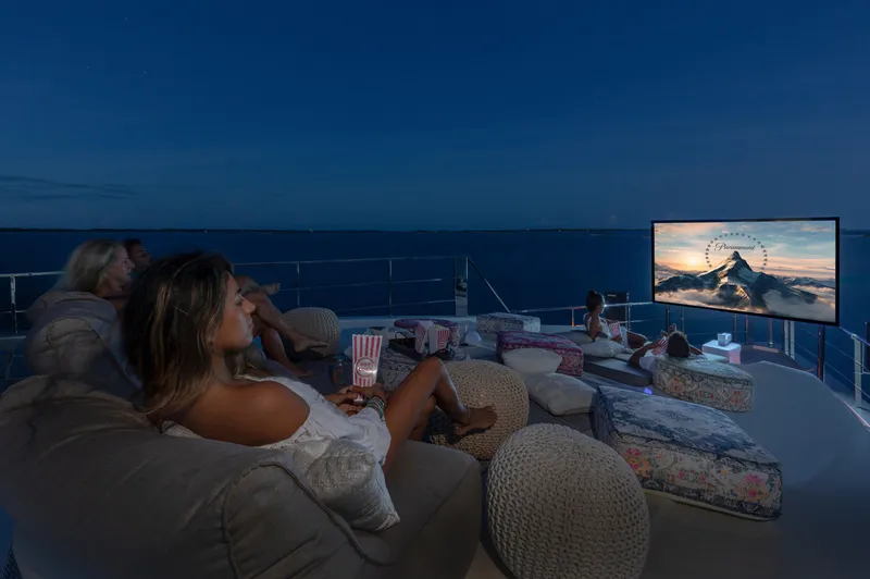 Safe Haven Yacht Photos Pics Outdoor movie night on a 2015 Admiral Custom yacht, featuring cozy seating and ocean views.