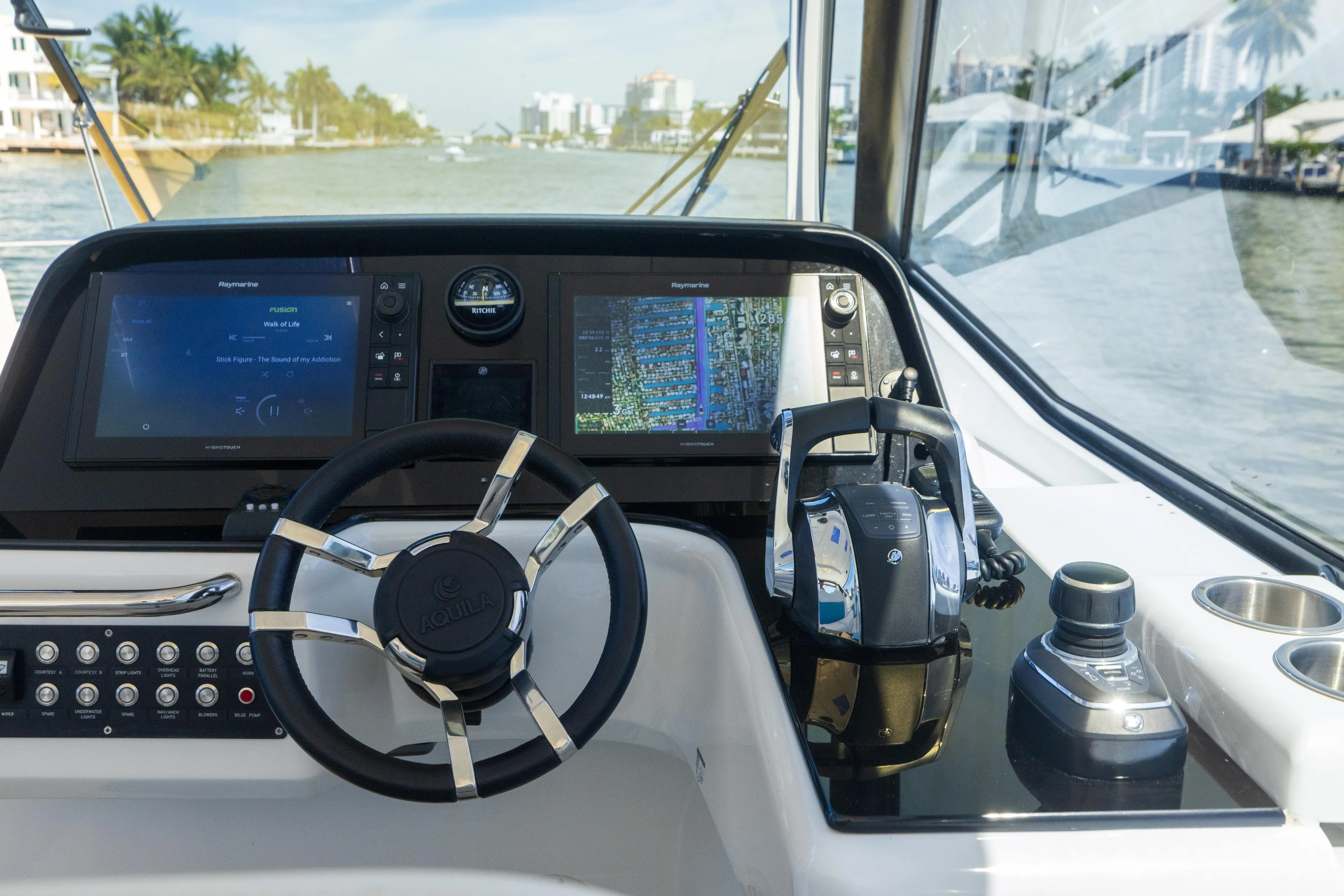  Yacht Photos Pics Control panel of 2019 Aquila 36 Sport boat with steering wheel and navigation screens.