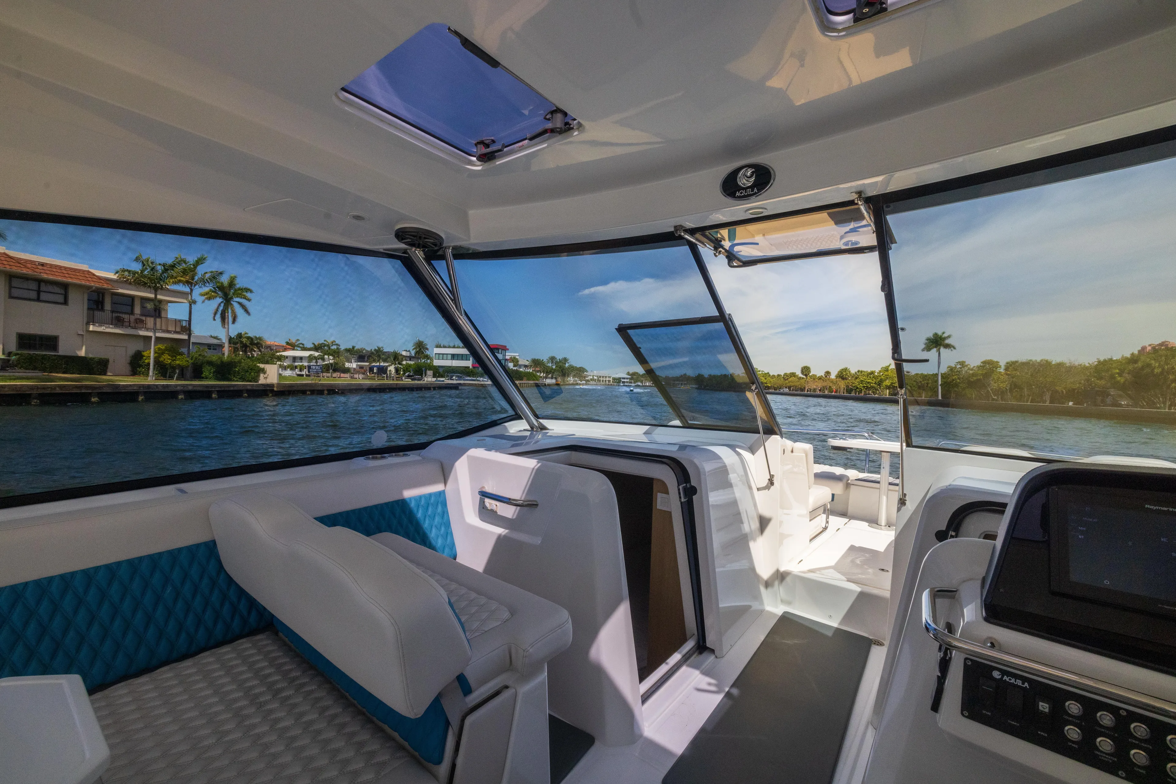  Yacht Photos Pics Interior view of 2019 Aquila 36 Sport boat with modern seating and scenic waterway.