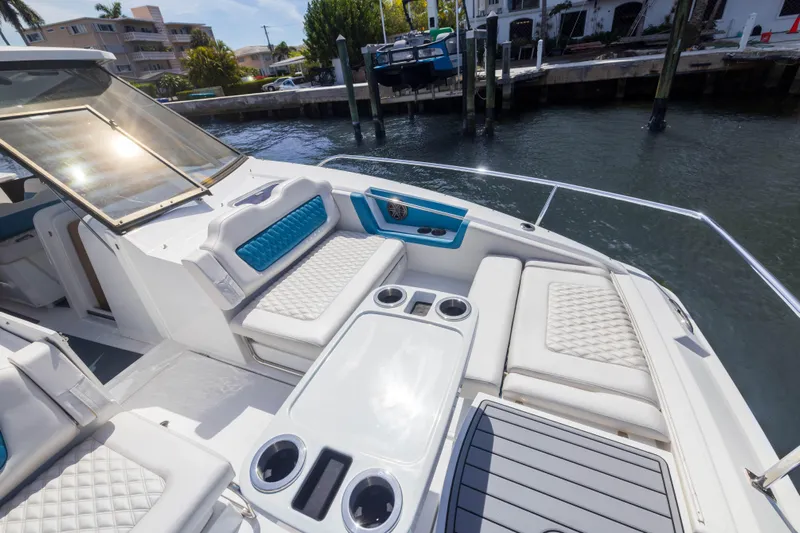  Yacht Photos Pics Aquila 36 Sport 2019 boat with luxurious seating and cup holders, docked by the water.