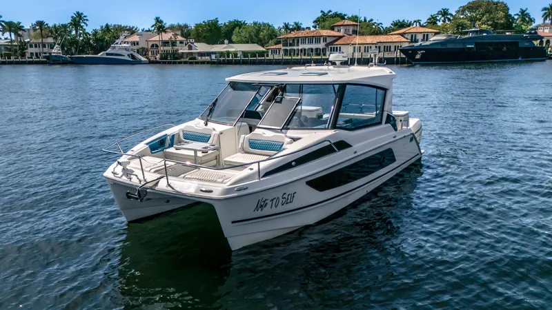  Yacht Photos Pics 2019 Aquila 36 Sport boat on a serene waterfront with luxury homes in the background.