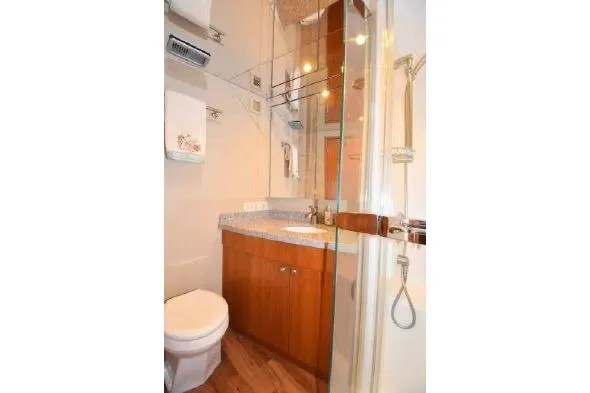 Bucket List Yacht Photos Pics 2013 Hatteras GT54 yacht bathroom with modern fixtures and wooden cabinetry.