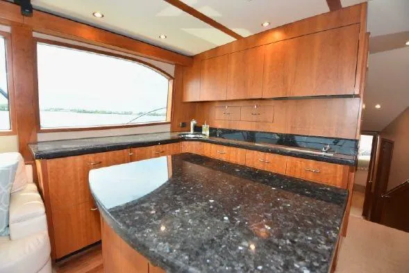 Bucket List Yacht Photos Pics Luxurious interior of 2013 Hatteras GT54 yacht with sleek wooden cabinetry and granite countertops.