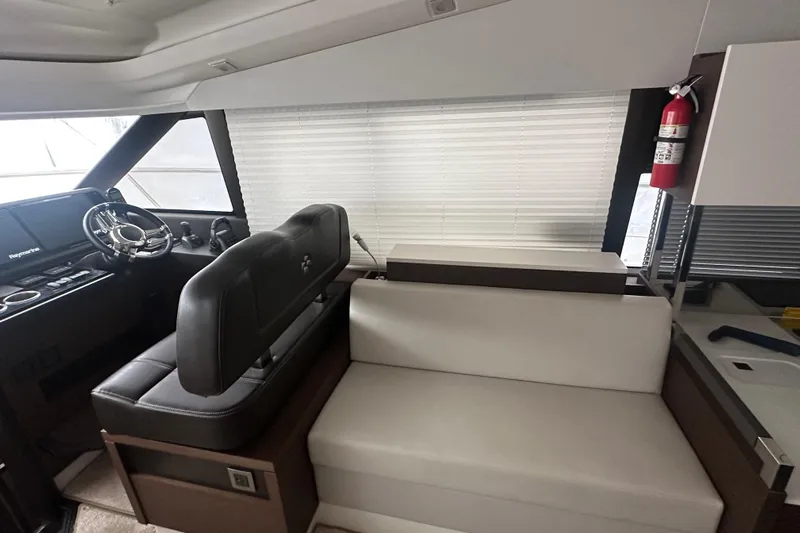 World Wide Yacht Photos Pics Interior of 2020 Prestige 460 yacht with helm, seating, and fire extinguisher.